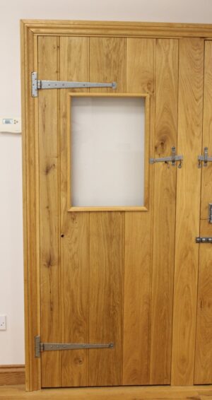 Bespoke oak ledge and brace door with a customizable glazing panel, showcasing the natural beauty of oak and innovative design.