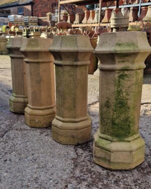 "Four octagonal buff chimney pots, ideal for rooftop décor, crafted with reclaimed materials for a rustic touch."
