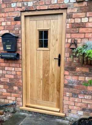 Handcrafted bespoke oak door with a robust design and warm, inviting wood textures, made to order for a personalized touch to your home's exterior.